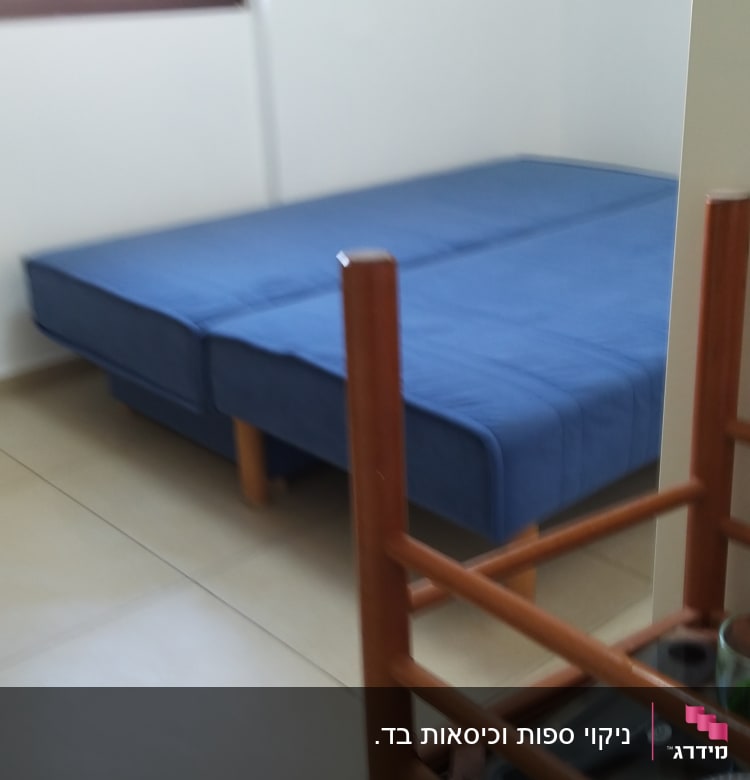 ספה כחולה בחדר עם רצפת אריחים